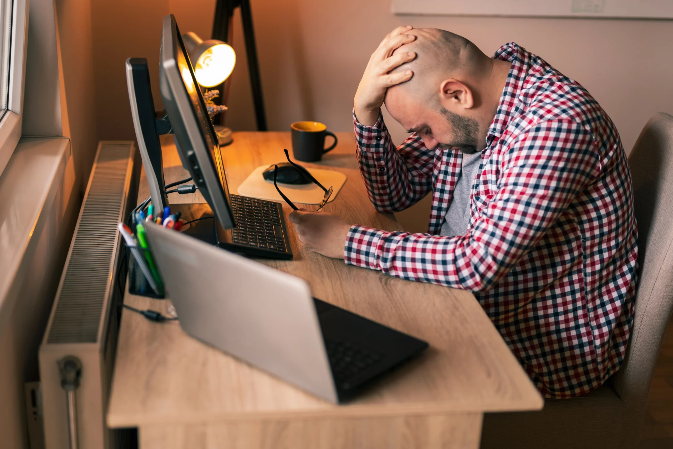 Stressed man sitting near Laptop