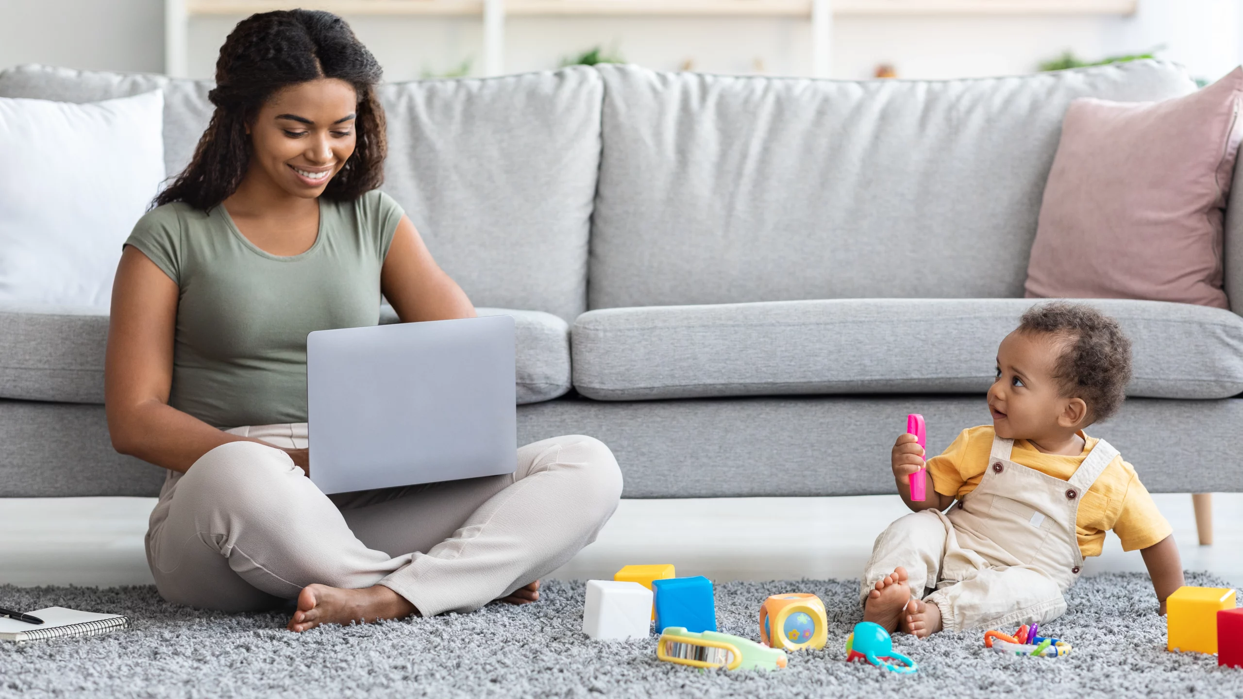 Woman working from home while watching her baby.