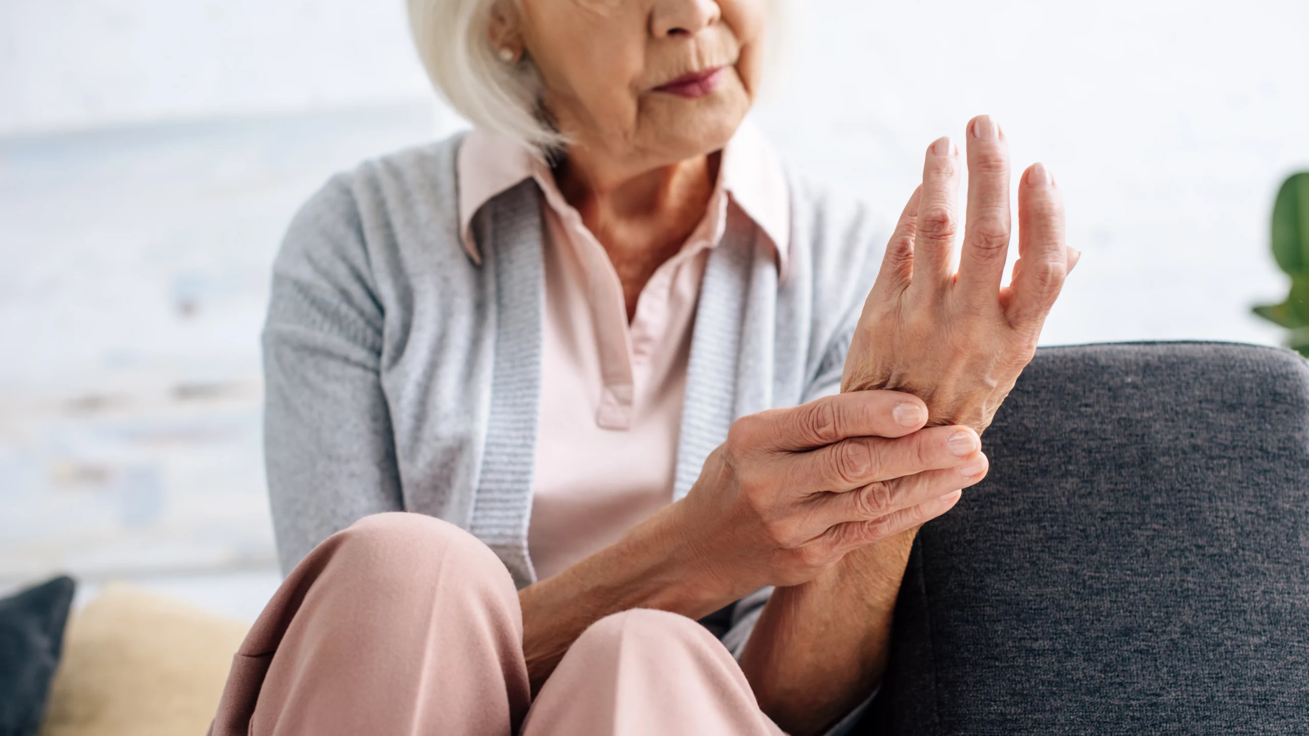 Cropped view of senior woman holding her wrist because of joint pain.