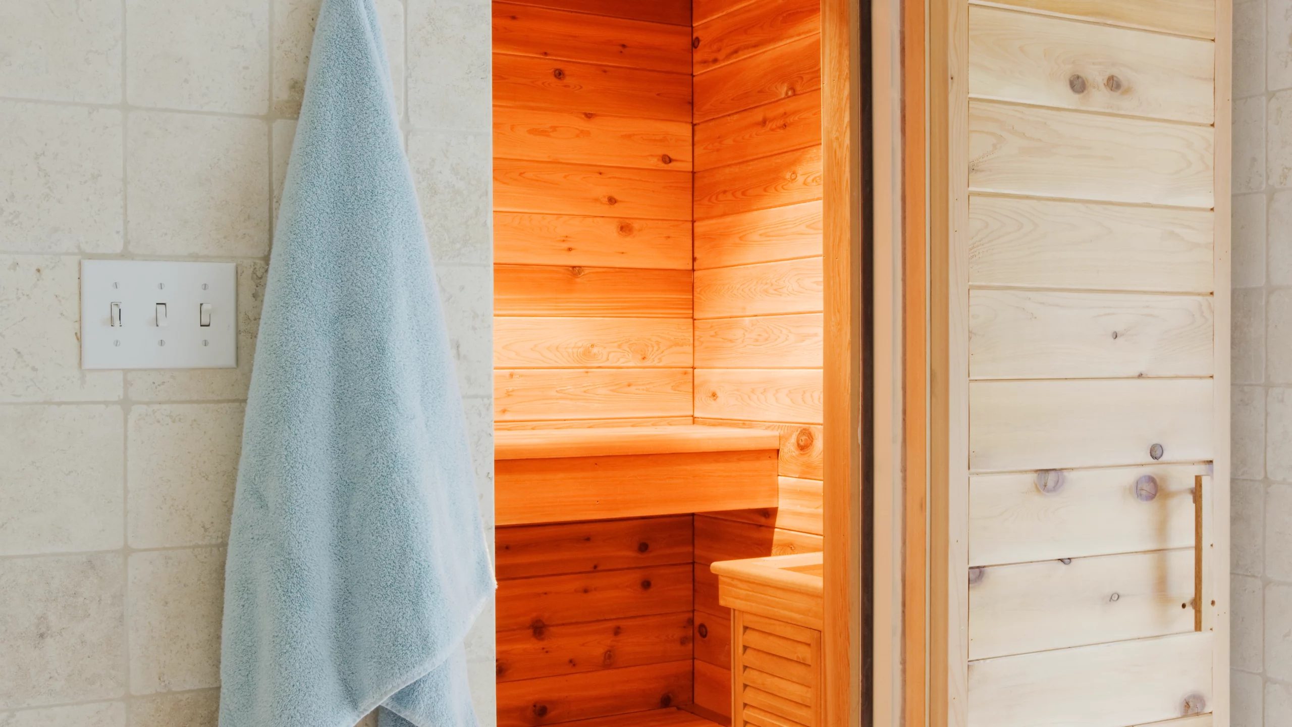 Light blue towel hanging by dry sauna door.