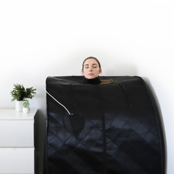 A woman looks very relaxed as she uses the UltraLux Foldaway Sauna